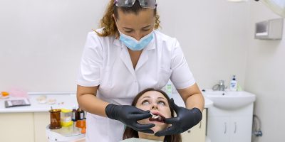 Partial denture, mature woman patient sitting in dental chair, doctor dentist doing dental prosthesis. Healthcare, medical and dentistry concept