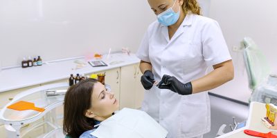 Partial denture, mature woman patient sitting in dental chair, doctor dentist doing dental prosthesis. Healthcare, medical and dentistry concept